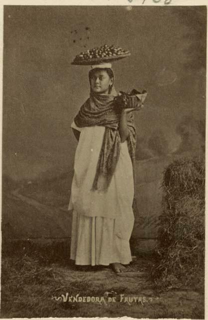 Studio portrait of Maya woman carrying fruit