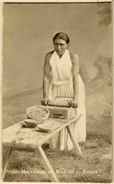 Studio-staged scene of Maya woman grinding corn