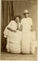 Studio portrait of two Maya men and a bundle of fibers