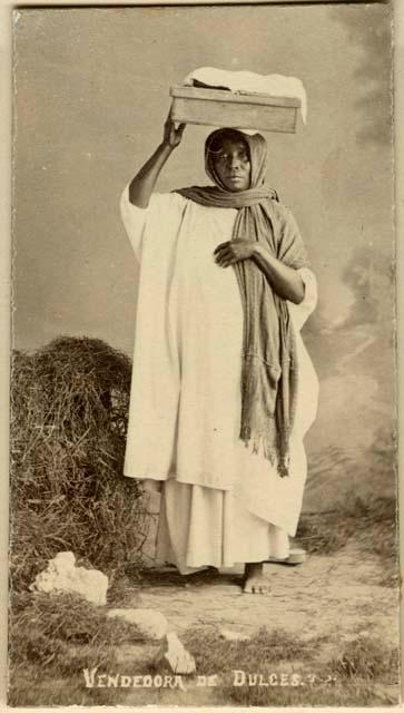 Studio portrait of Maya woman holding a box on her head