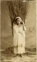 Studio portrait of Maya woman with a large bundle on her back