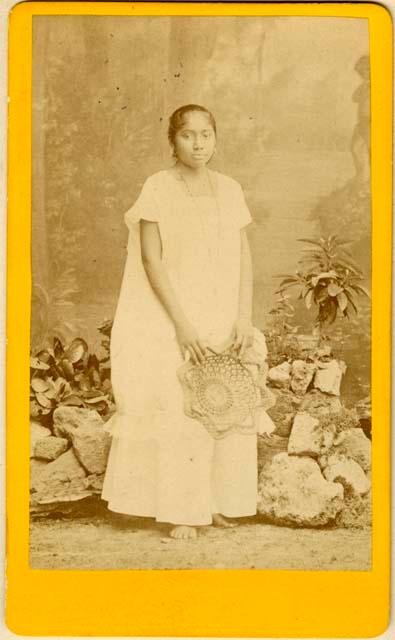 Formal studio portrait of Maya woman holding a woven decoration