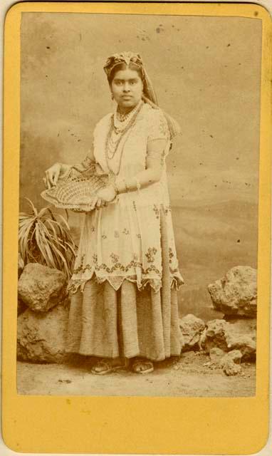 Formal studio portrait of Maya woman holding a woven decoration