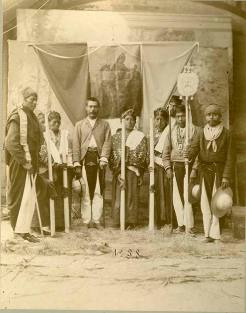 Quiche Indians: group portrait of men and women standing with banner