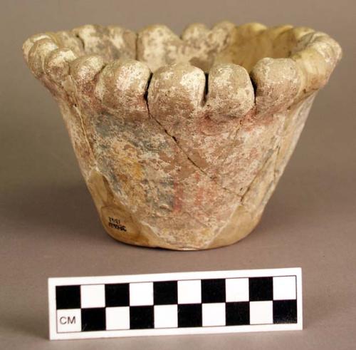 Restored pastel polychrome pottery ring base with clay balls around edge.