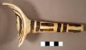 Fragment of black on yellow pottery ladle--end of handle, reworked