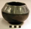 Small pottery jar. Globular with incurved rim, highly polished black ware with