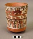Vase painted in polychrome with frontal and profile trophy heads, step frets