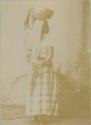 Studio portrait of Maya woman holding basket on head