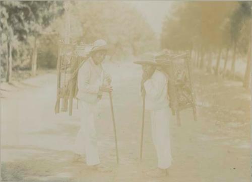 Two Maya men stopped on dirt road