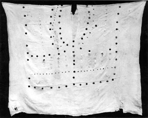 Peruvian gold: cloth with holes and metal ornaments, ripped