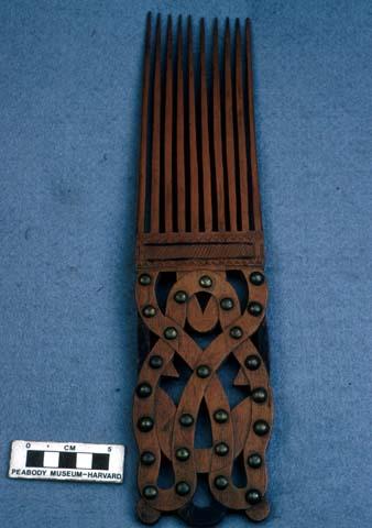 Carved wooden comb with metal knobs as part of decoration