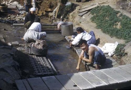 People washing themselves and clothing in a stream