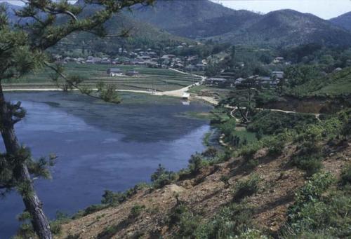 View of lake with town and hills in distance