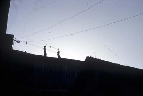 Men on wall below power lines