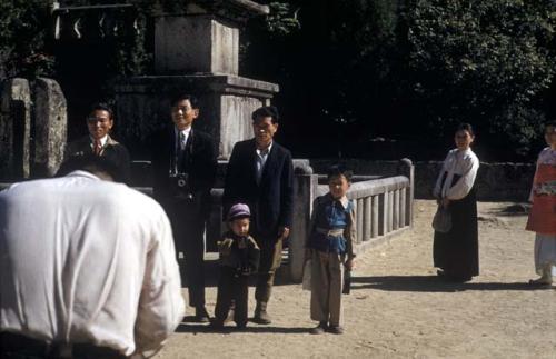 Adults and children having photo taken in front of monument