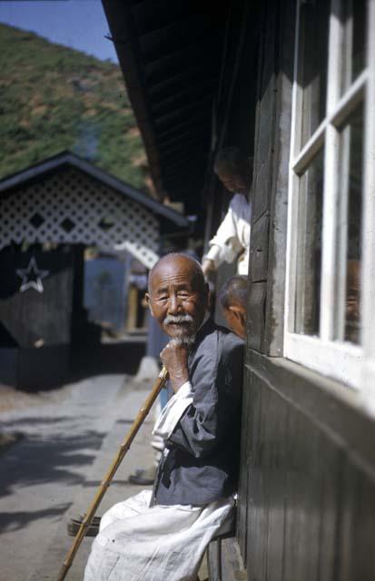 Monk seated in front of building