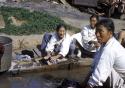 People washing clothes in stream