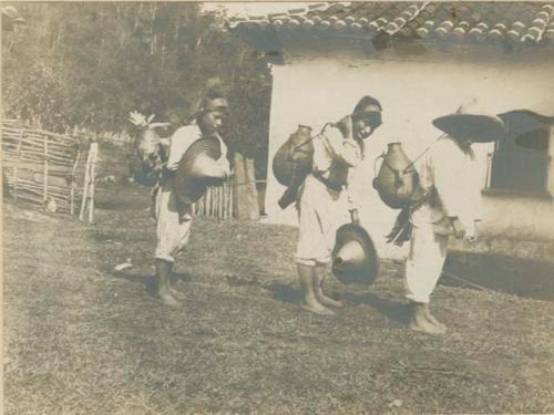 Three boys carrying vessels