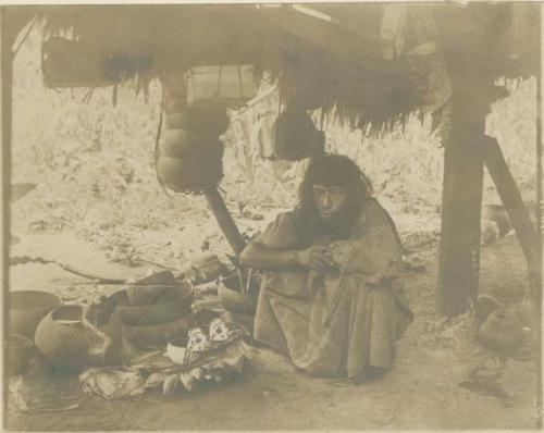 Maya Indian seated beside some pottery