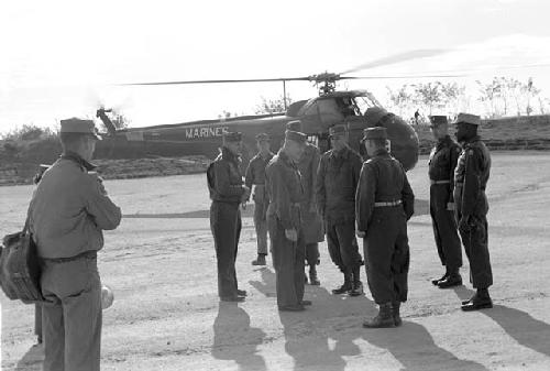 Soldiers standing near helicopter