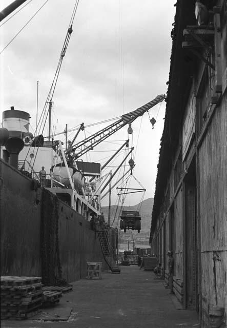 Crane lowering jeep from ship to ground