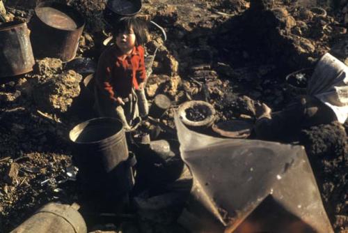 Girl walking in pile of garbage and dirt