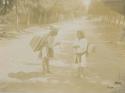 Two boys on a tree lined road