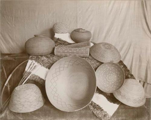 9 baskets, varying in size and shape. Most have geometric and spiral decorations