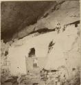 Frederic Ward Putnam and another man climb wall of Cliff Palace