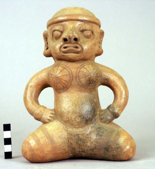 Pottery figure - yellowish brown with darker paint of same colorr applied in spo