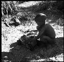 Child playing with a toy car made from an expedition file box and film reels