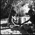 Two children playing with a toy car made from an expedition file box and film reels