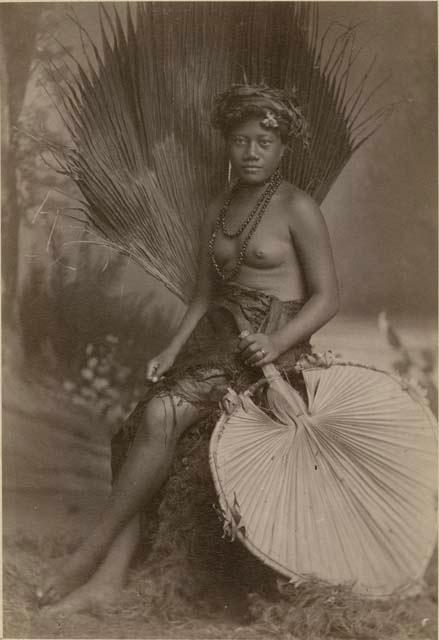 Samoan woman posed with a palm fan