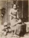 Young Samoan woman posing, about to crack a coconut