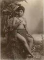 Samoan girl, in a studio-staged scene, holding a large leaf