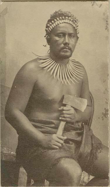 Samoan man posed holding an ax, studio portrait