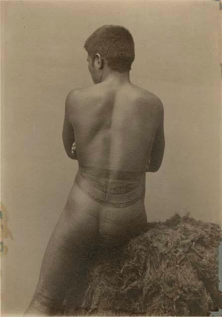 Portrait of Samoan man, back view, showing traditional tattoos from waist to knees