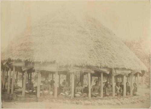 Men seated around the fale tele, or meeting house