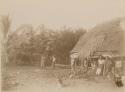 Samoan women and children outside of long house