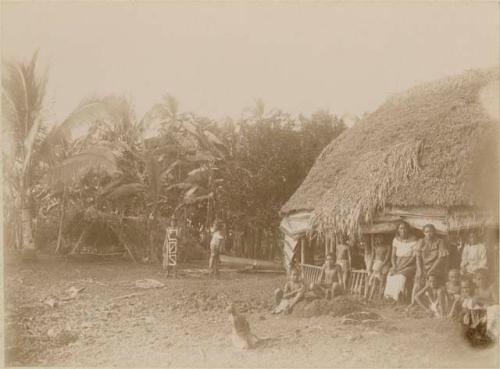 Samoan women and children outside of long house