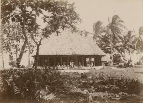 People seated outside the fale tele, or meeting house