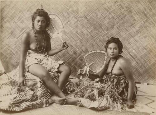 Two young Samoan women pose with fans