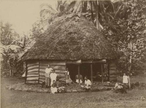 Family outside of round house, or fale tele