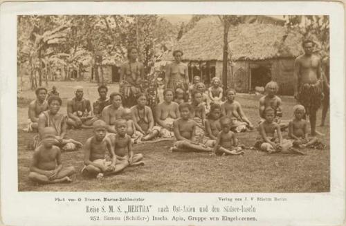 Group of adults and children in front of a structure