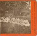 Group of women seated on ground in western dress