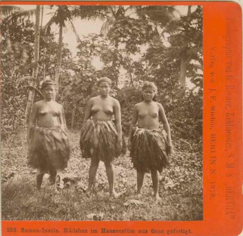 Three young women wearing grass skirts