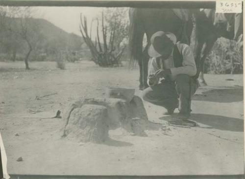 Man squatting, examining something