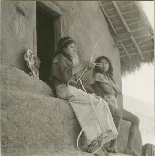 Young boy seated at door of the temple to 'Our Father Sun' braiding a hat.