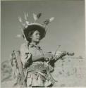 Huichol man, a peytote pilgrim, holding a decorated violin